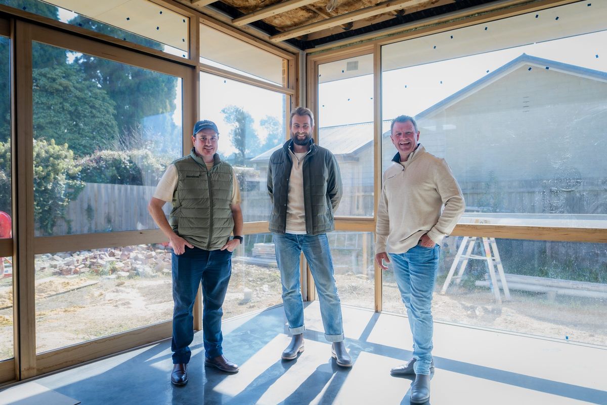 Leigh, Ged and Jason inside a timber-framed home under construction